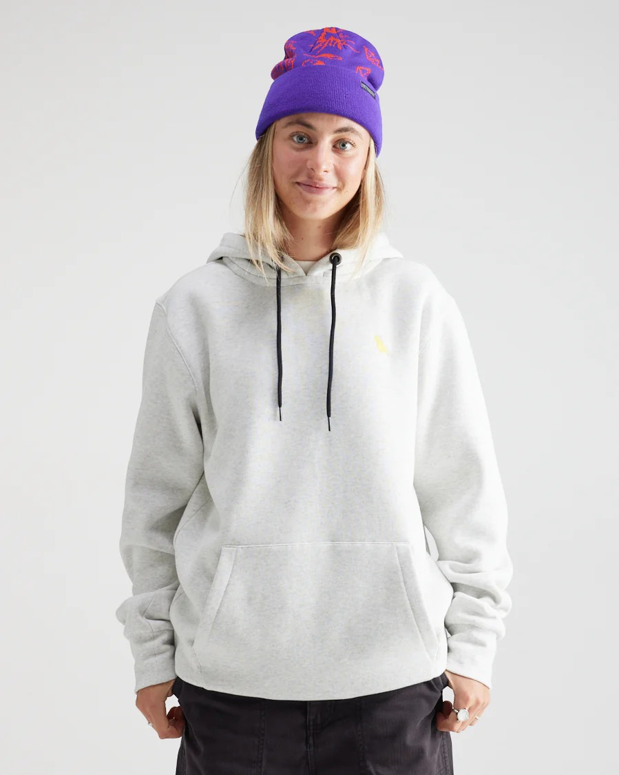 Person wearing a gray hoodie and purple beanie with floral design on a white background